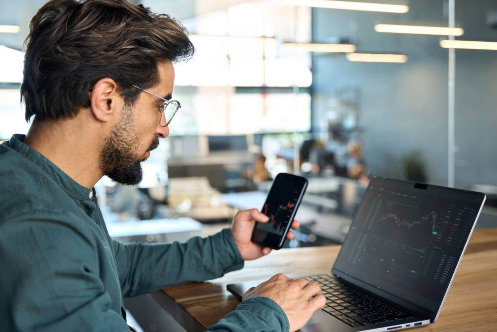 professional working on cellphone and computer