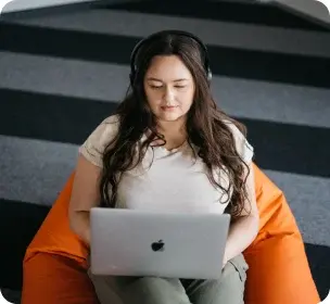 endava employee working on laptop in soft orange chair