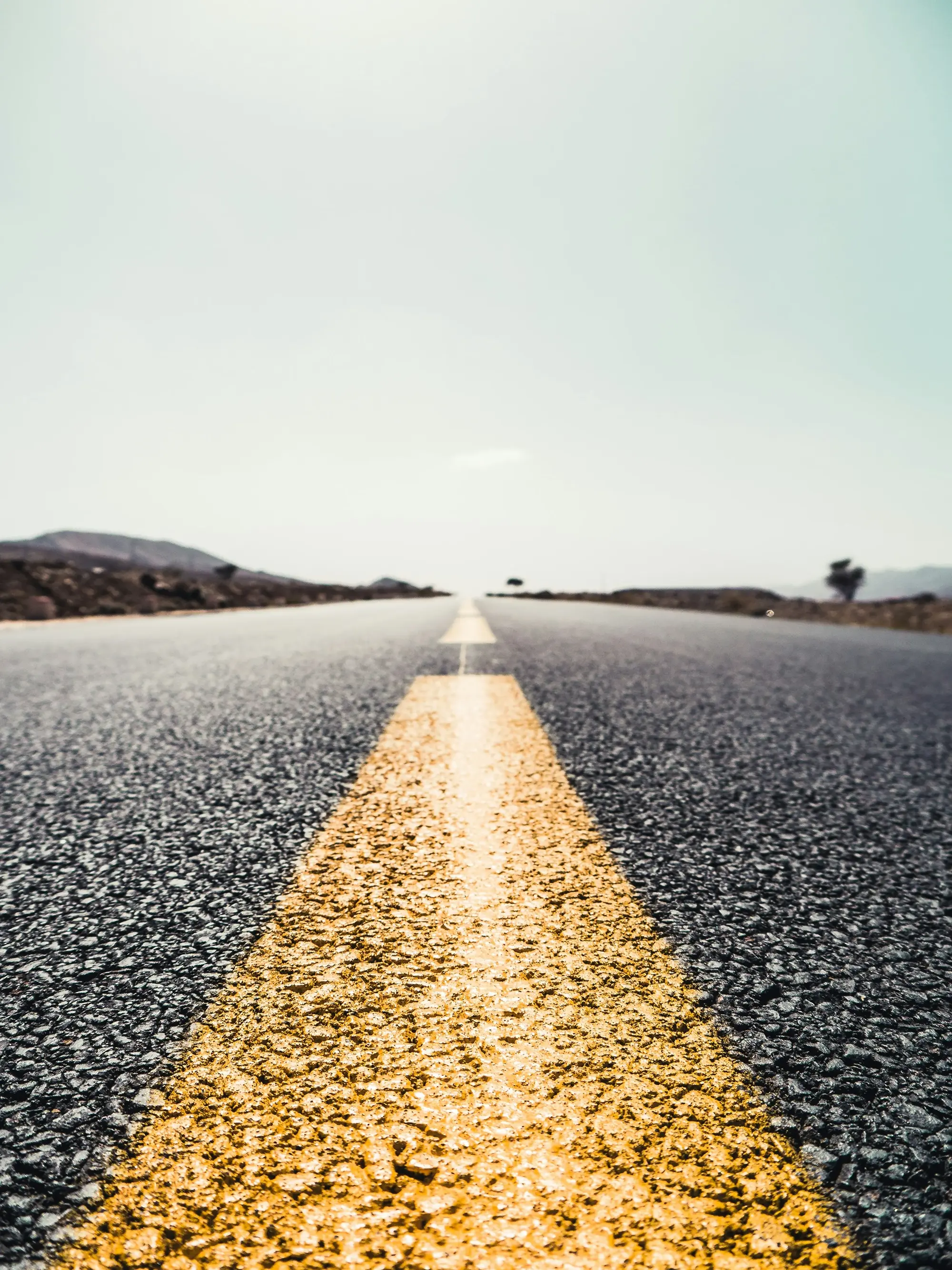 A long empty road with a yellow line on it, symbolizing the modernization of critical operating systems for a top financial services giant.