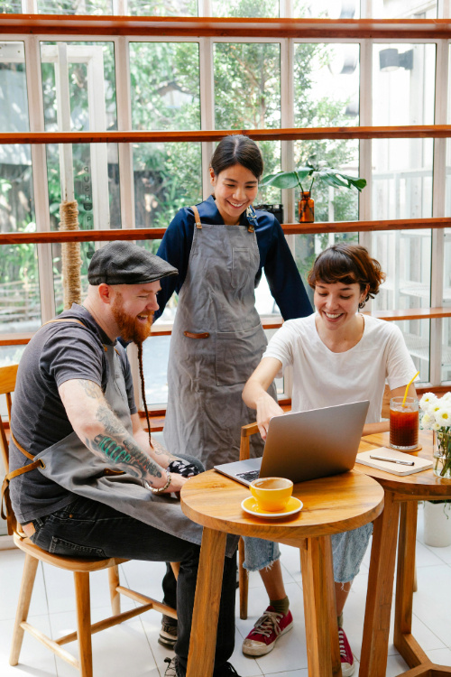 Two People in a coffee shop working on a laptop