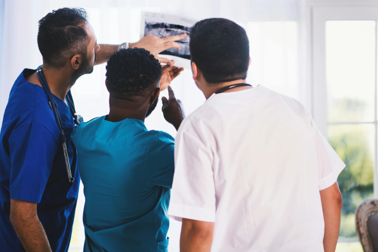 three doctors looking at X-RAY