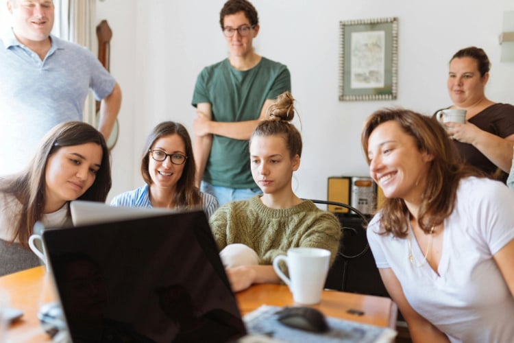 A group of colleagues watching a presentation on a laptop