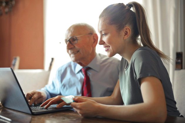 A woman and a man watching something on a laptop