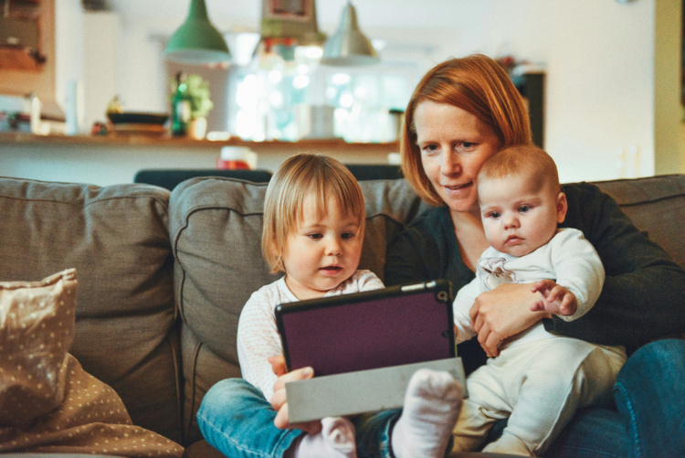 A woman sitting down wit her two babies