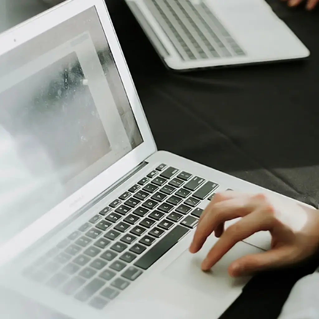 Person working on a laptop with technical diagrams on the screen, symbolizing embedded technology and digital transformation.