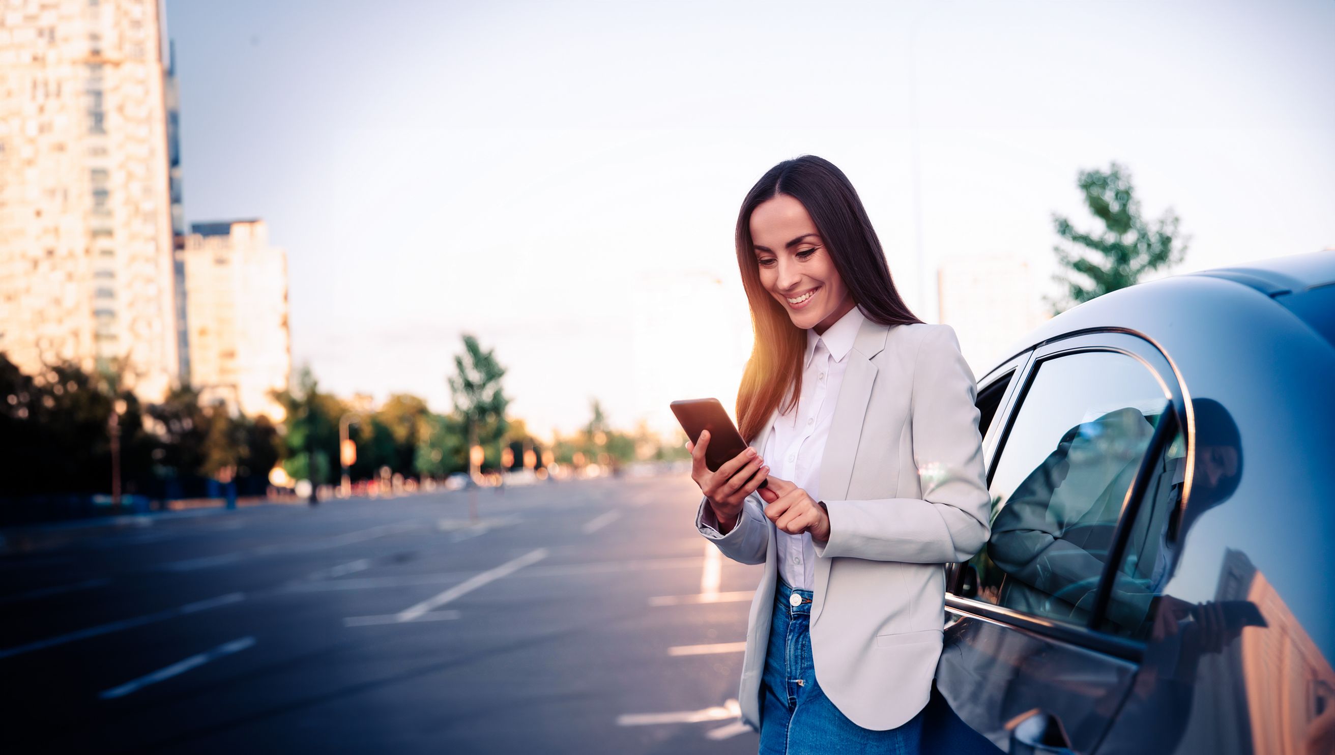 Woman at the phone standing by her car