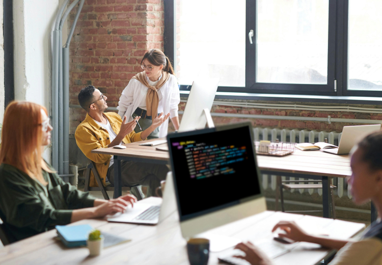 A group of people working at desks in an office, collaborating in a professional and organized environment