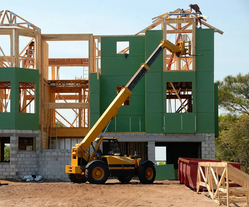 home exposed wood construction site with crane and green boards