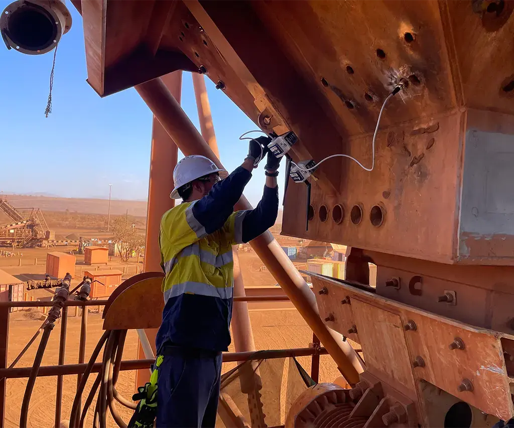 man-working on large mining equipment in orange desert region