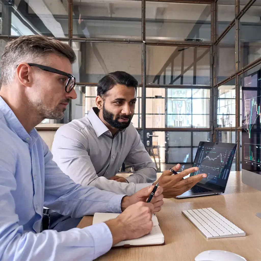 two business men reviewing stock charts on the computer