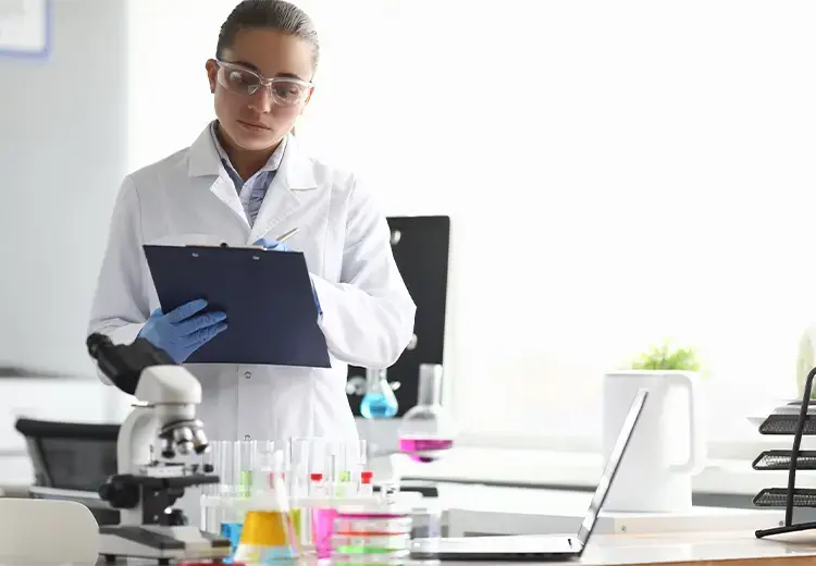 woman working in lab with colorful beakers