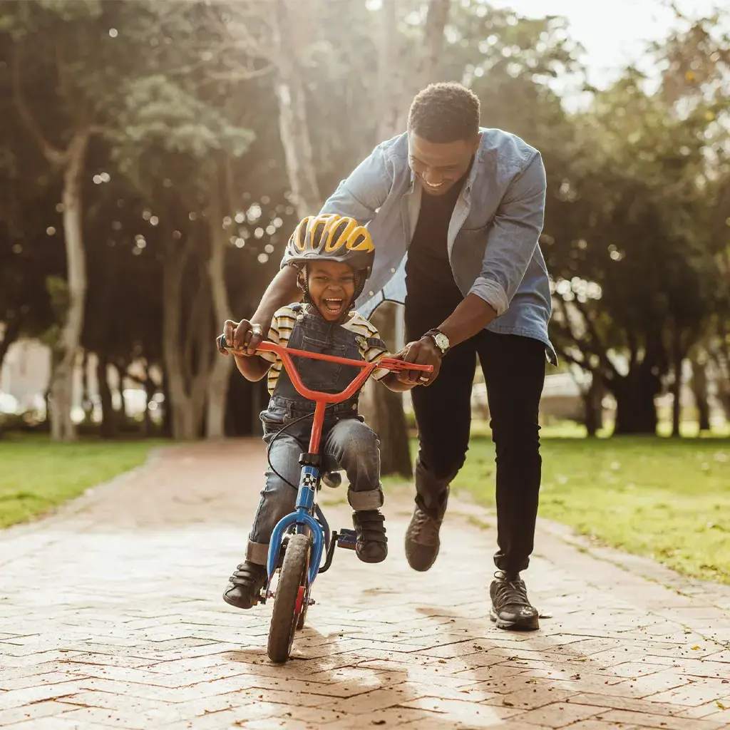 Father teaching his son ride a bike safely