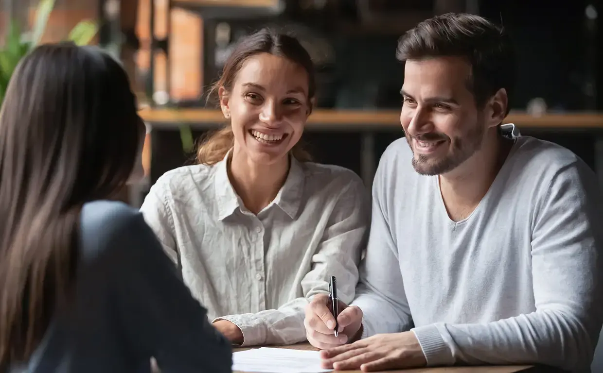 couple meeting with another insurance business woman at table with paperwork