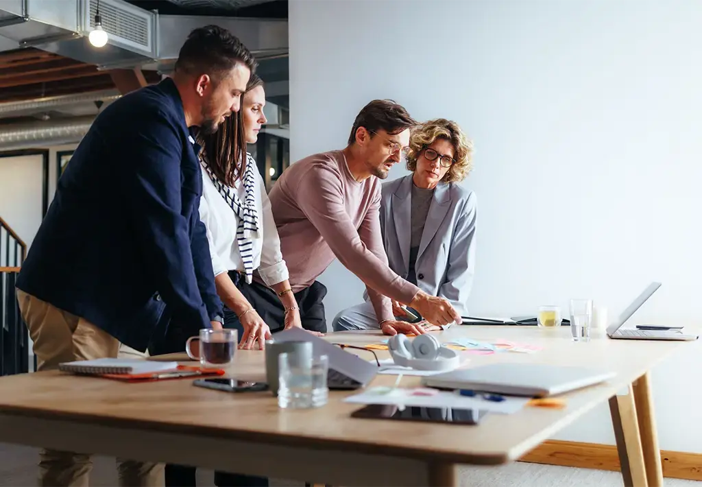 creative team reviews sticky notes on a wood desk