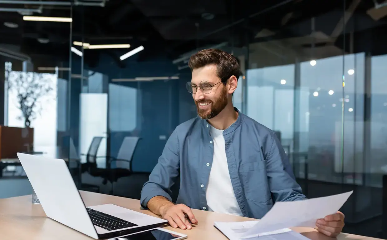 man processing payments on laptop in office