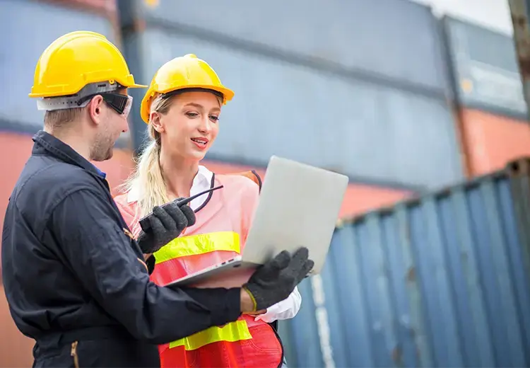 man and woman digitally check shipping container logistics