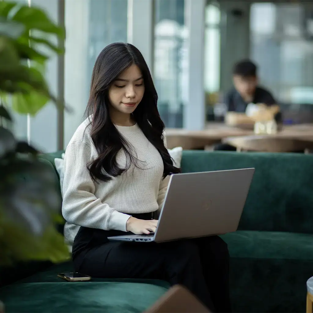 young asian woman working on laptop at Endava Kuala Lumpur offices