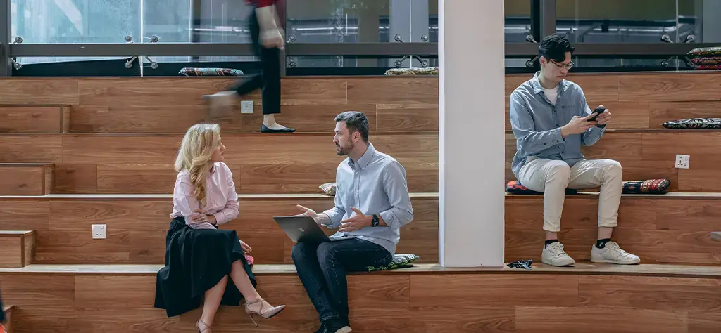 endava coworkers sitting on wood seating