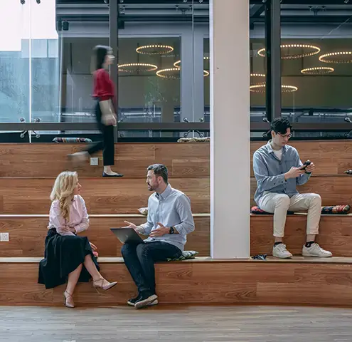 endava coworkers sitting on wood seating