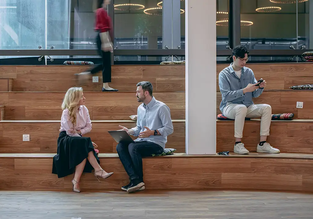 endava coworkers sitting on wood-seating