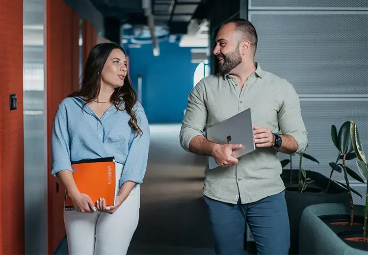 two endava coworkers walking and talking in hallway