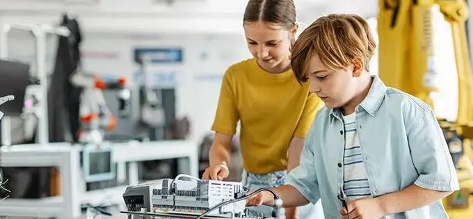 boy and girl working on computer electronics circuitry 