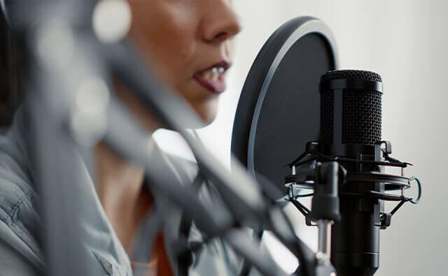 woman speaking into podcast microphone