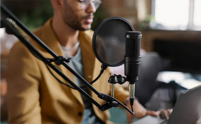 man sitting behind podcast microphone