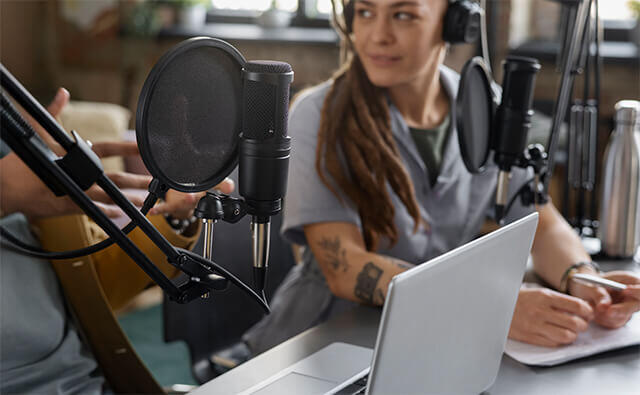 woman smiling at podcaster at her side