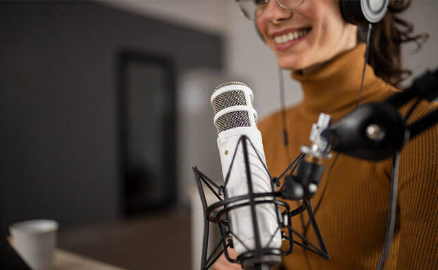 woman smiling with earphones on ready for podcast