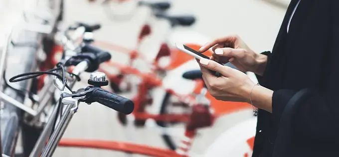 woman using a mobile phone  near rack of bicycles