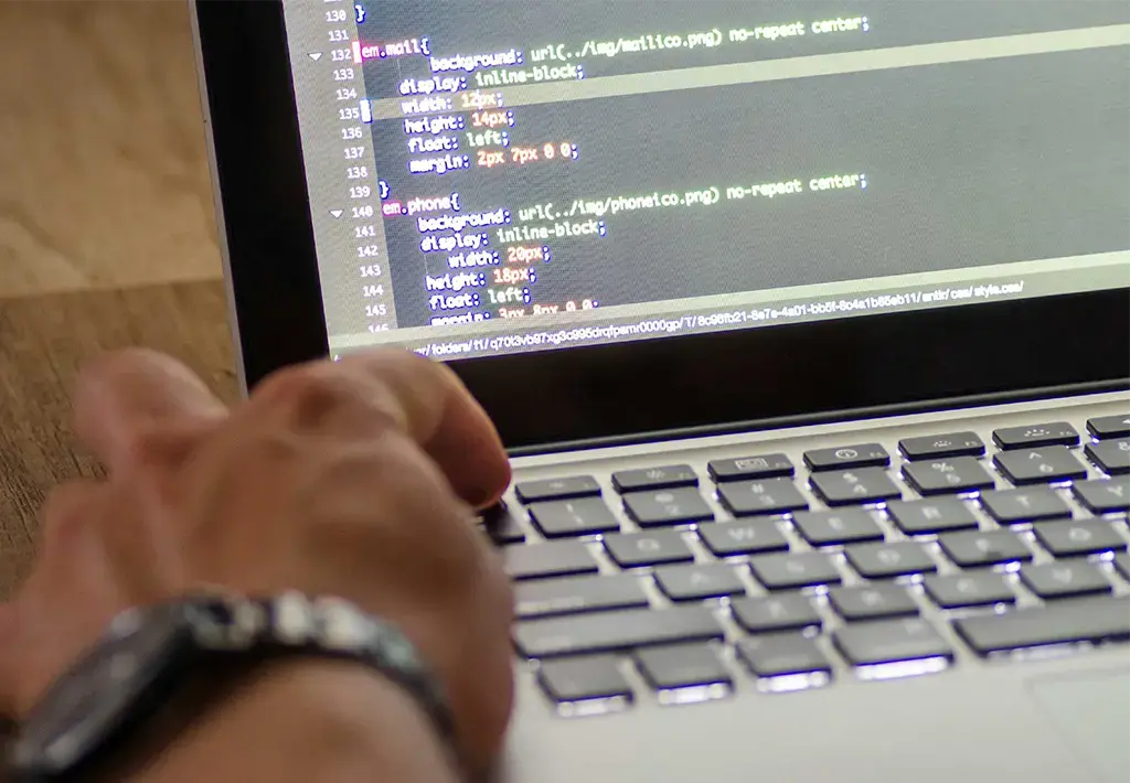 close up of mans hand working on coding on laptop