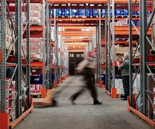 warehouse worker walking through inventory shelves