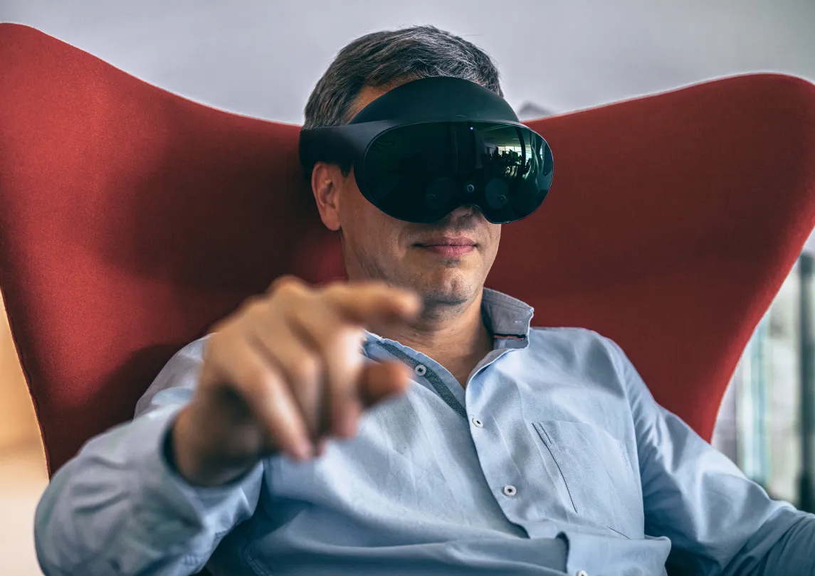 A man sitting on a chair wearing a VR headset