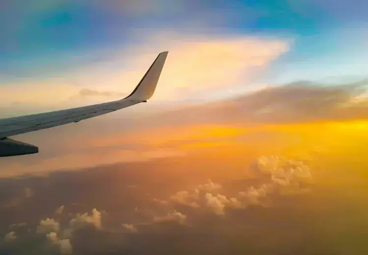 view up the air of airplane wing at sunrise