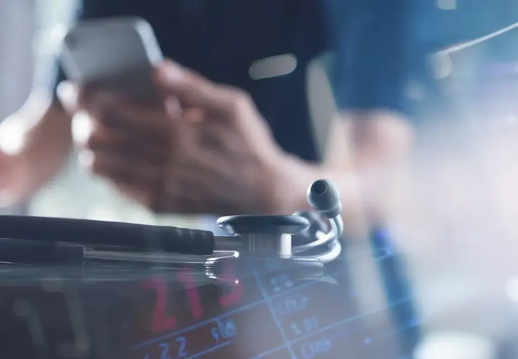 doctor holding phone by medical equipment 