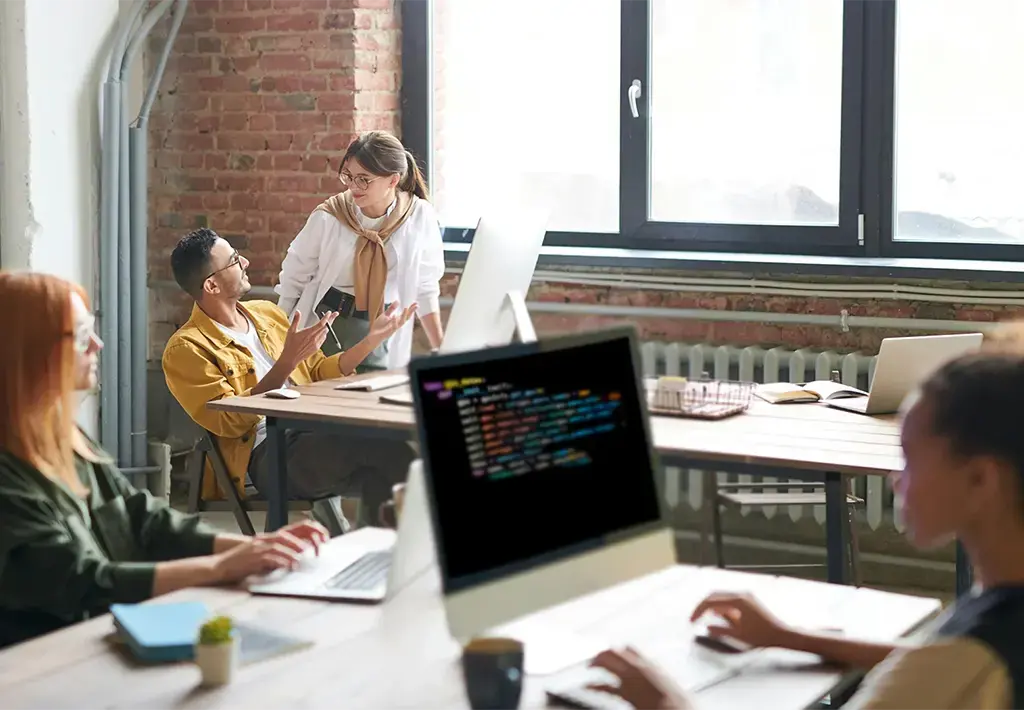 man and woman talking in shared office space