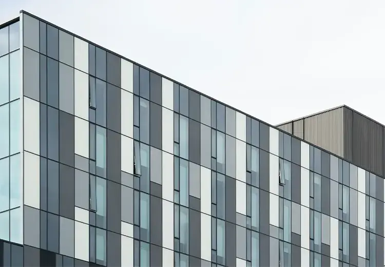 view up to the sky of the glass windows on an office building