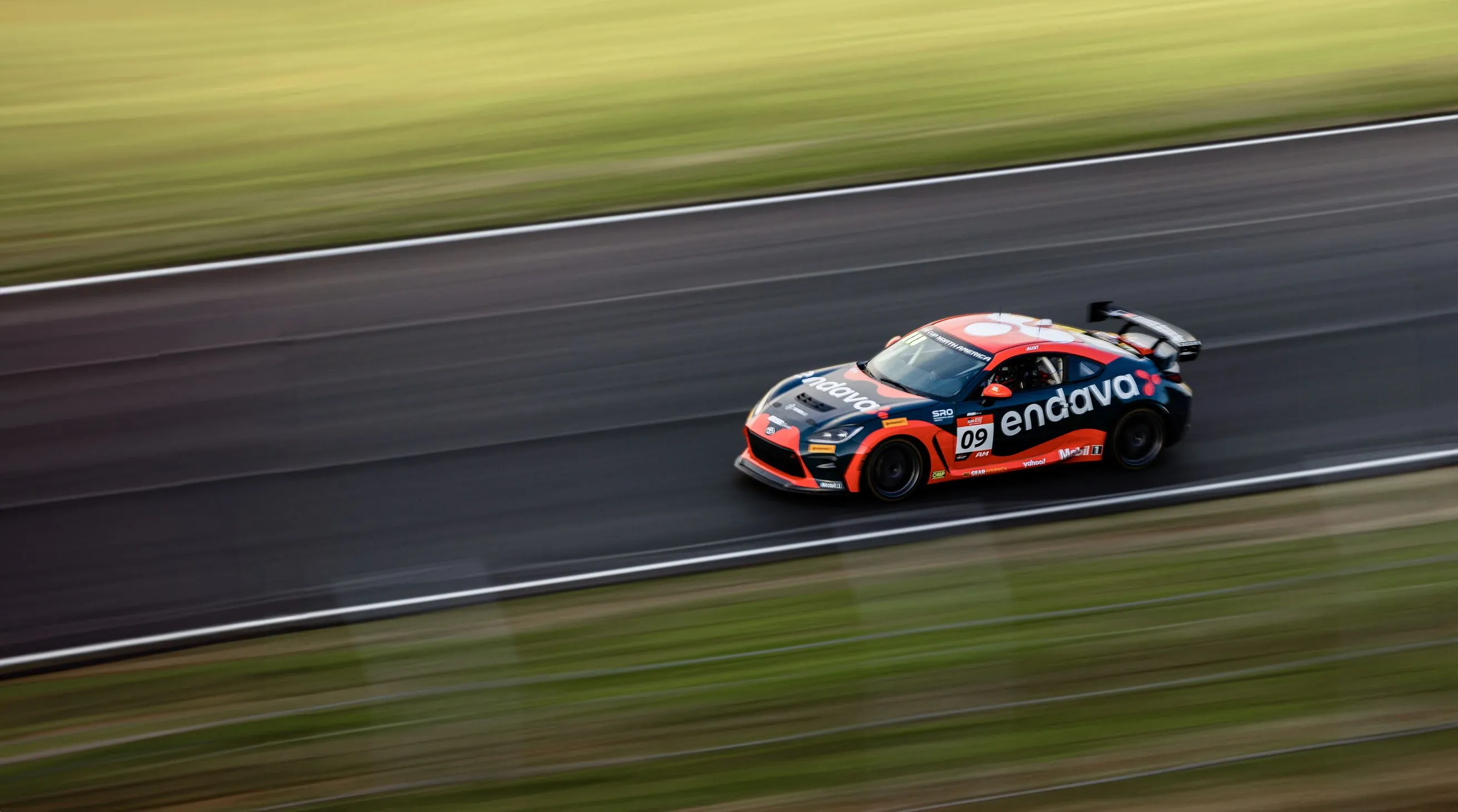 An Endava branded race car driving on the track.