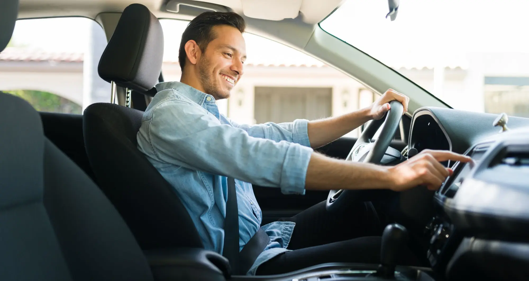 Driver smiling while using the car's touchscreen infotainment system.