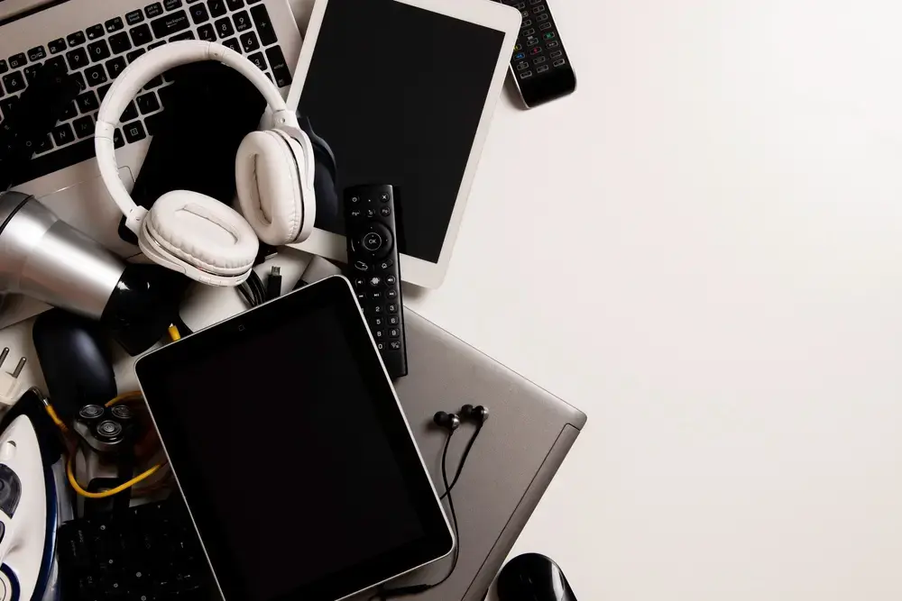 electronic devices in a pile on a desk