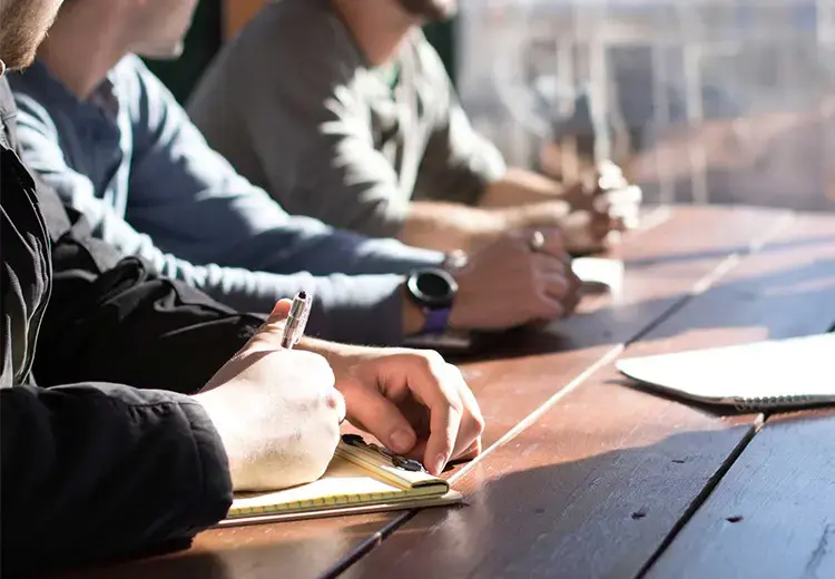 office employees rest forearms on meeting table