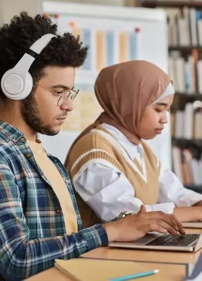 A group of people working with laptops on a library