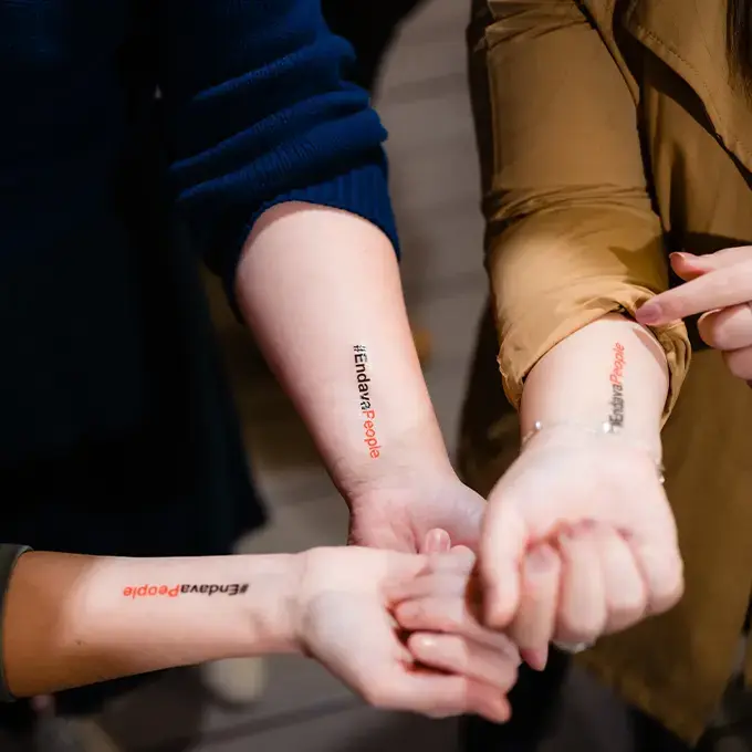 three womens showing their forearms covered in endava stickers